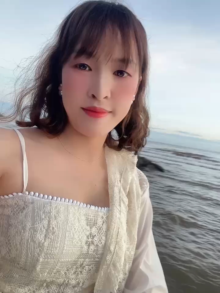 woman in a white lace top by the sea, ChatSpace TV profile